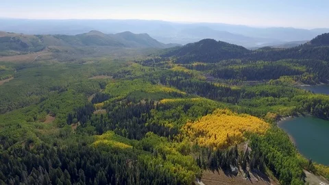Aerial shot of mountain landscape with trees changing yellow secluded lake Stock-Footage 87190875