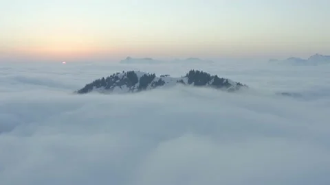 Aerial shot of a mountain in a sea of clouds at sunset, in Switzerland Vídeos de archivo 196884408