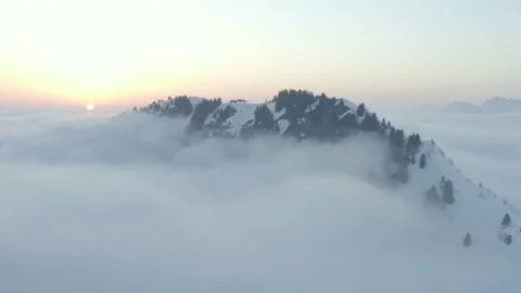 Aerial shot of a mountain in a sea of clouds at sunset, in Switzerland Stock Footage 196885367