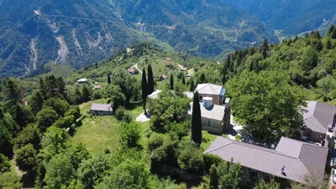 Aerial shot of mountain settlement below Byzantine monastery and cliff Stock Footage 343943924