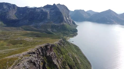 Aerial shot of mountain summit with steep drop-off to the ocean in Norway Stock Footage 340504375