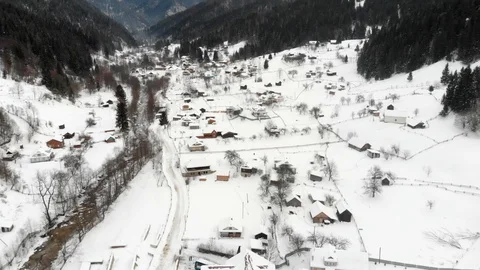 Aerial shot of a mountain valley with settlement and road placed between steep Stockbeeldmateriaal 126242591
