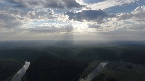 Aerial shot of mountains covered with coniferous forest with River and sun rays Stock Footage 75473653