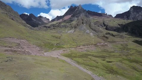 Aerial shot of Mountains, Roads, Clouds and fields. Following the road. Stock Footage 75951153