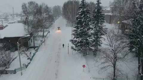 Aerial shot in movement to the left over snowed town with road when snow-storm Stock Footage 166281128