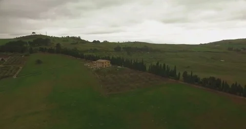 Aerial shot moving backwards over green fields Stock Footage 76917128