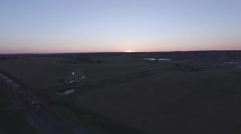Aerial shot moving cargo train camera pulling away during sunset Stock Footage 60133465