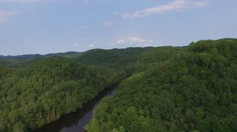 Aerial shot moving down river with hills and forest 動画素材 52081168