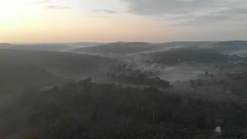 Aerial shot moving forward over a tropical forest with mountains and mist 스톡 동영상 160338943