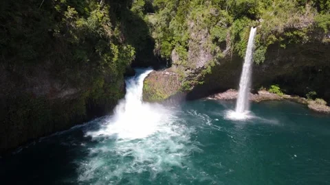 Aerial shot moving to the right of two waterfalls, with turquoise colors. Stock Footage 299627265