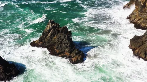 Aerial shot off a ocean cliff side revealing a sea stack rock formation Stock Footage 288876868