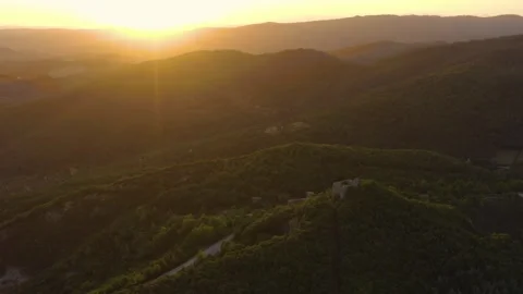 Aerial shot of an old castle at sunset in the mountains of Tuscany, Italy Stock Footage 286306541