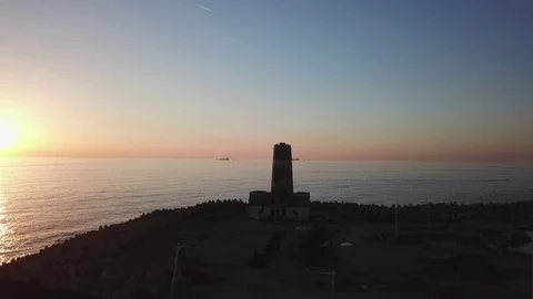 Aerial shot of an old lighthouse abandoned against the sunset Stock Footage 98317236
