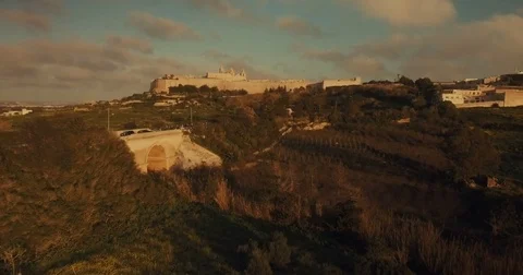 Aerial shot over fields and trees moving towards Mdina Stock Footage 73474773