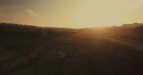 Aerial shot over green fields during sunset Stock Footage 73469037