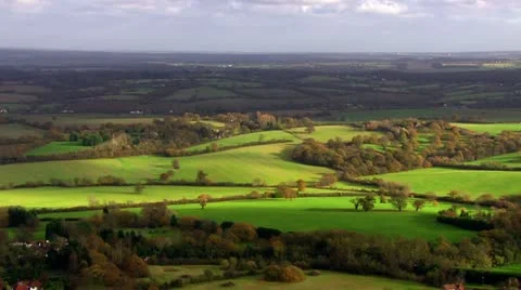 Aerial shot over lush green fields and meadows in the English countryside Stock Footage 18112416