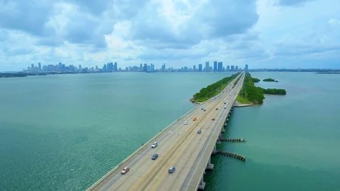 Aerial shot over road on top of water in Miami, Florida, buildings in background Stock Footage 96232059