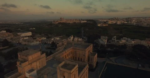 Aerial shot over a school in Rabat moving towards Mdina Stock Footage 73473246