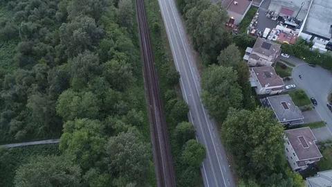 Aerial Shot Over Train Tracks Road And Office Buildings Beside Forest River Stock Footage 100532258