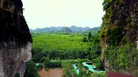 Aerial Shot passing through Mountains into Palm Trees Field, Krabi, Thailand. Stock Footage 153573373