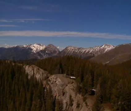 Aerial shot of pine forests, distant snowy mountains Stock Footage 21601059