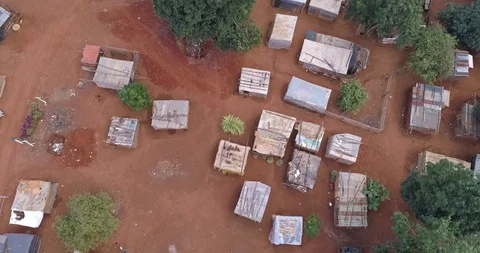 Aerial shot of poor farming village in rural Africa with makeshift structures Stock Footage