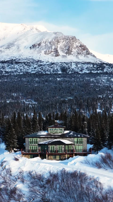 Aerial Shot Pull out of Lodge in snowy wintry scene with snowcovered mountain Stock-Footage 333606832