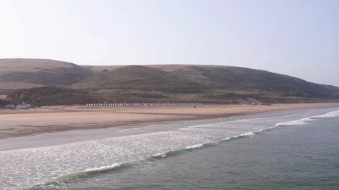 Aerial Shot Pulling Away from Sandy North Devon Beach and Tilting Down to Stock Footage 113040448