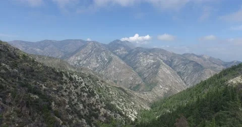 Aerial shot pulling back over forested mountains Video stock 57926405