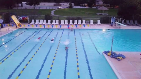 Aerial shot pulling backwards of people swimming in a lap pool Stock Footage 285431405