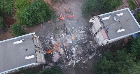 Aerial shot of pulling down the building by means of machinery Stock Footage 124621713