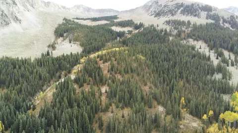 Aerial shot pulls away from mountainside revealing blue lake Stock Footage 104152737
