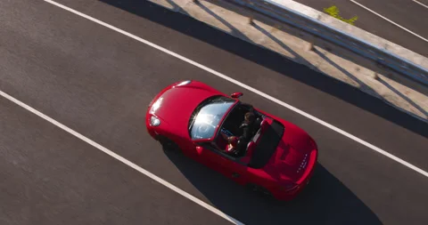 Aerial Shot Of Red Sportscar Cabriolet Driving On Beautiful Road Through Stock Footage
