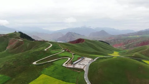 Aerial Shot of Red Yellow Layer Rock Grass Mountain Mountain Bend Road Stock Footage 337946267