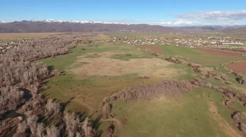 Aerial shot of a river in fields and town in springtime Stock Footage 62586715