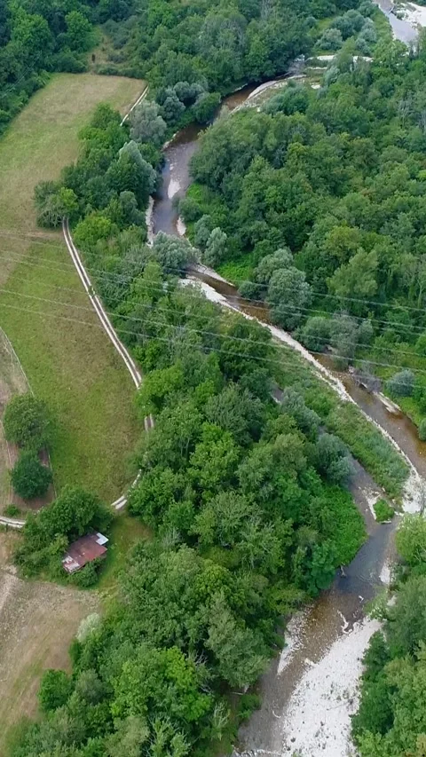 Aerial shot of river going through a forest, fields and villages nearby Stock-Footage 225555873