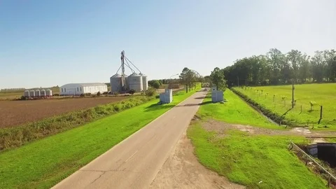 Aerial shot in the route with a car passing and agricultural silos Stock Footage 78884341