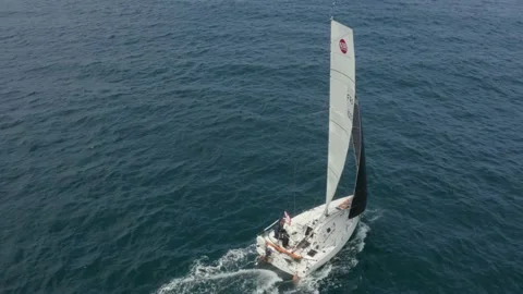 Aerial shot of a sailor pulling his sails on a boat in the ocean Stock Footage 195115924