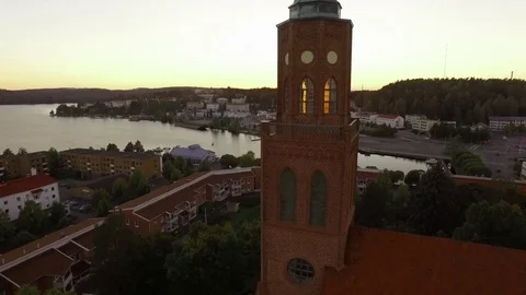 Aerial shot of the setting sun blinking through church tower windows in Stock Footage 69728525