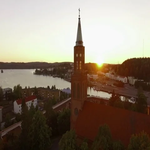 Aerial shot of the setting sun blinking through church tower windows in Stock Footage 69728579
