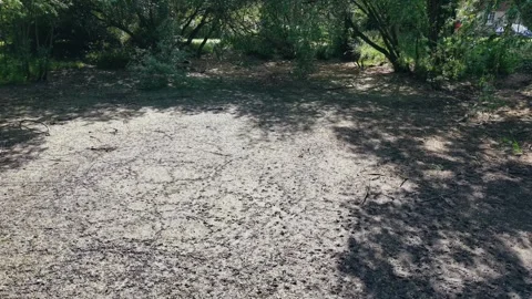 Aerial shot of a shallow drying riverbed with cracked ground during summer Stock Footage 309769697