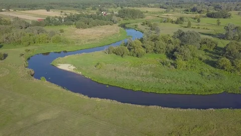 Aerial shot of small, curvy river on the green meadow. Stock-Footage 79622724