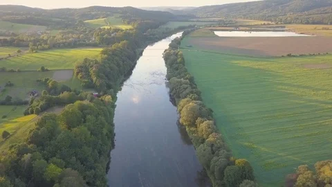 Aerial shot of small, curvy river on the green meadow. Stockbeeldmateriaal 80500061