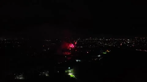 Aerial shot of small red multishot fireworks exploding at night Stock Footage 255596245