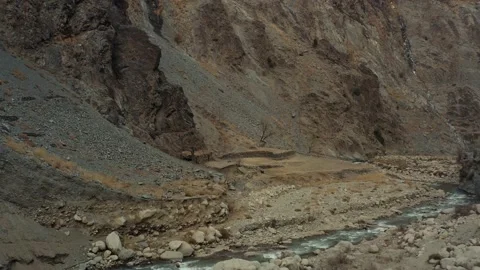 Aerial shot of a small river stream in the mountains of Kalash valley Pakistan Stock Footage 170562950