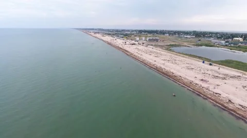 Aerial shot of straight Black Sea coast with people, canopies, and white sand Video stock 137442953