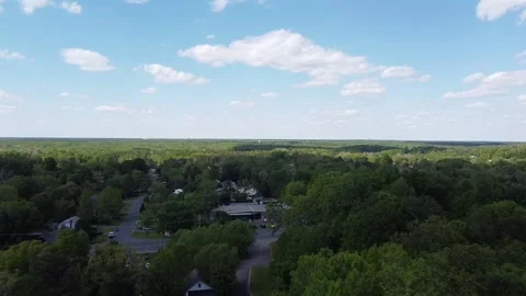 Aerial Shot of Suburban Town Being Revealed Over Trees Stock Footage