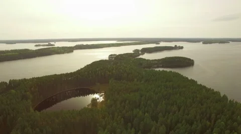 Aerial shot of sun reflecting from a small pond inside an island Stock Footage 68031153