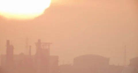 Aerial shot of sun setting behind industrial landscape, evening Stock Footage 104786623