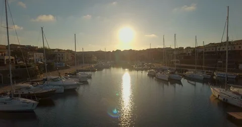 Aerial shot of sun setting over little harbor in Stintino on Sardinia, Italy Stock Footage 128378595